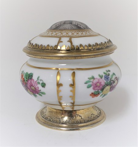 Royal Copenhagen. Bonbonniere porcelain lid with motif from Kastellet, 
Copenhagen. Mounting of gilded sterling silver, A. Michelsen, Copenhagen 1920. 
H. 9 cm.