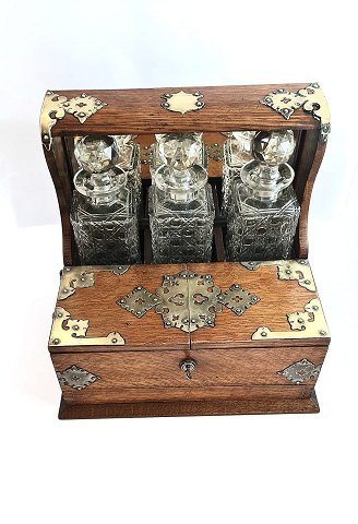 Tantalus. In oak with 3 decanters. There is 2 storage rooms. Height 32 cm. Width 25 cm. Length 34 cm.