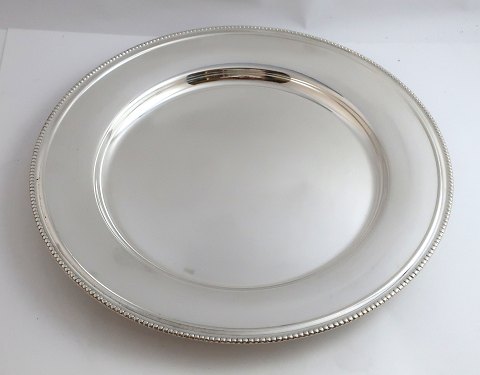 12 silver plated cover plates with pearl edge. Diameter 28 cm. Traces of wear on 
a few pieces.